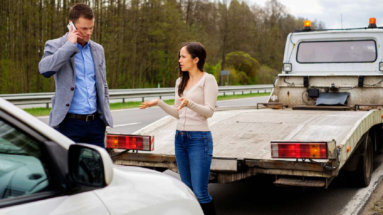 This image shows a black car being towed.
