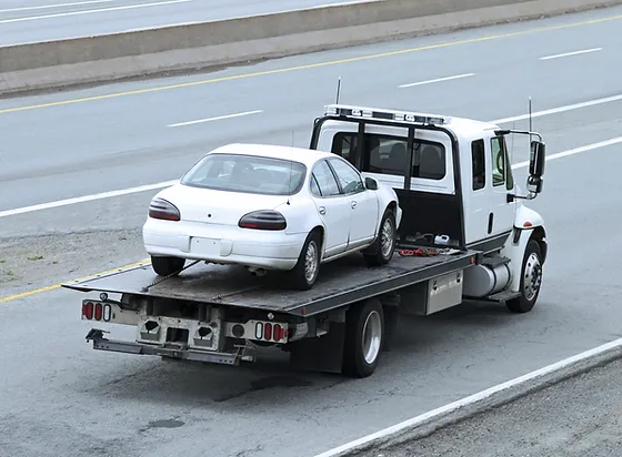 This image shows a black car being towed.